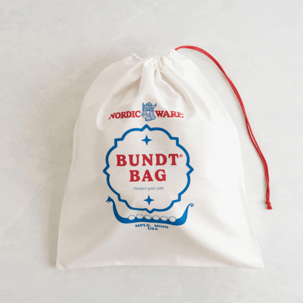 Nordic Ware bundt pan sliding out of gray protective storage bag, demonstrating zippered closure and fit