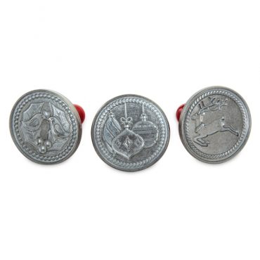 Three aluminum cookie stamps with red wooden handles featuring festive holiday designs in relief