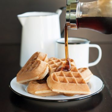 Nordic Ware cast aluminum heart-shaped waffle maker with cooked golden waffle, showing detailed heart pattern