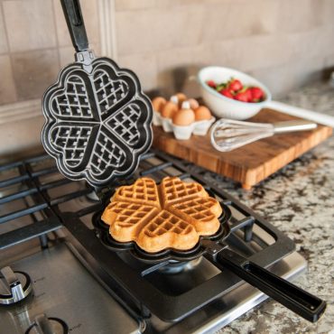 Nordic Ware cast aluminum stovetop waffler with heart-shaped cooking surface, silver finish with black handles