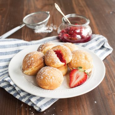 Nordic Ware cast aluminum ebelskiver pan with 7 round wells, filled golden spherical pancakes with jam