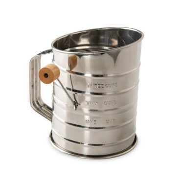 Nordic Ware aluminum flour sifter with black handle, wooden knob lever, and measurement markings on side