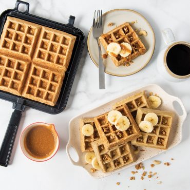 Nordic Ware black stovetop Belgian waffler with golden banana oat waffles served on plates with coffee