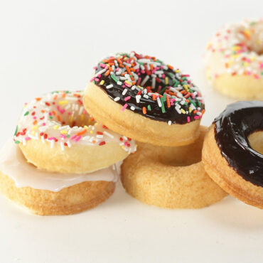 Nordic Ware aluminum donut pan with six glazed donuts, colorful frosting and sprinkles