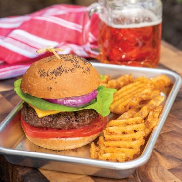 Nordic Ware aluminum burger serving tray with grilled hamburger, lettuce, onion, tomato and waffle fries