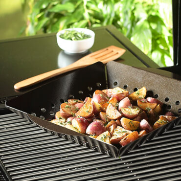Grill Basket filled with diced potatoes, on grill