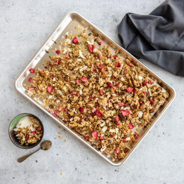 Golden toasted granola with nuts and dried fruit on Nordic Ware aluminum half sheet baking pan