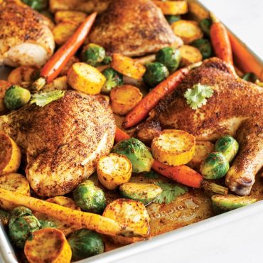 Golden-brown spiced chicken thighs with roasted vegetables on Nordic Ware aluminum big sheet baking pan