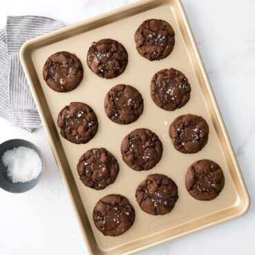 Nordic Ware aluminum half sheet pan with twelve baked chocolate chip cookies, golden nonstick surface