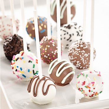Chocolate and vanilla cake pops with colorful sprinkles and drizzled chocolate made in Nordic Ware donut hole pan