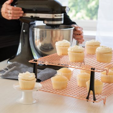Nordic Ware copper stackable cooling grids with vanilla cupcakes, wire mesh design with black support legs