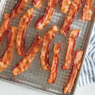 Crispy cooked bacon strips on Nordic Ware nonstick cooling grid set inside aluminum sheet pan
