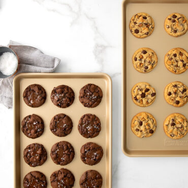 Two Nordic Ware aluminum half sheet pans with baked cookies - chocolate on left, chocolate chip on right