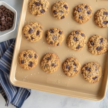 Golden chocolate chip cookies on Nordic Ware nonstick big sheet baking pan with light gold finish