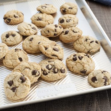 Golden chocolate chip cookies on Nordic Ware Prism aluminum jelly roll pan with textured ridged surface