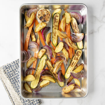Colorful roasted vegetables in Nordic Ware aluminum high-sided sheet cake pan, golden and caramelized