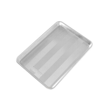 Nordic Ware aluminum jelly roll pan with textured prism interior pattern, natural finish, angled view