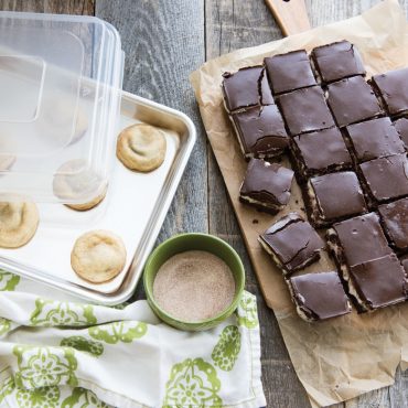 Three Nordic Ware Naturals aluminum baking pans stacked with lids, rectangular sheet pans in natural silver finish