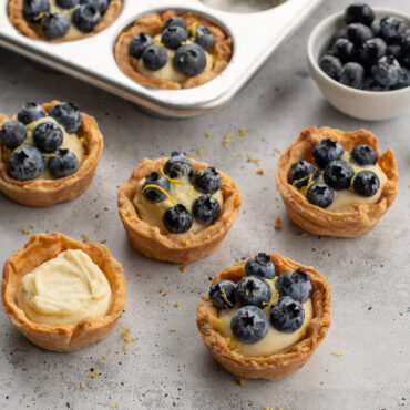 Golden baked tarts with fruit filling in Nordic Ware aluminum 12-cavity muffin pan, natural silver finish