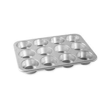 Nordic Ware Naturals aluminum 12-cup muffin pan, natural silver finish, angled view showing deep round cavities