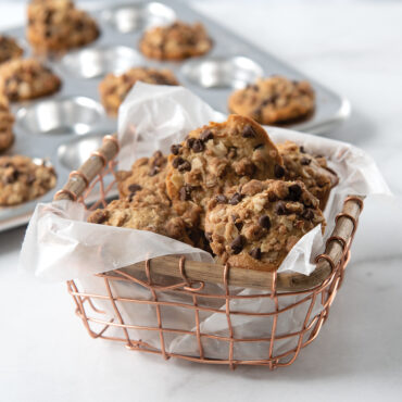 Nordic Ware aluminum 24-cavity petite muffin pan filled with golden baked granola muffins, natural finish