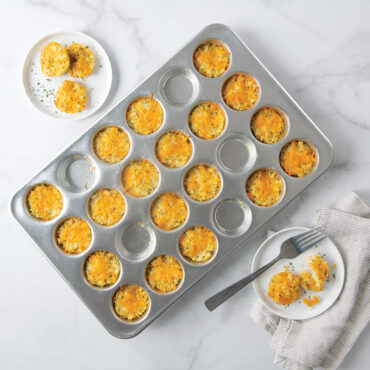 Nordic Ware aluminum 24-cavity petite muffin pan with golden baked egg bites, natural silver finish