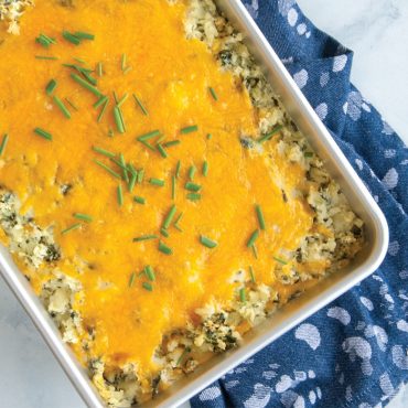 Cheesy potato casserole with melted cheddar and chives in Nordic Ware Prism aluminum 9x13 baking pan