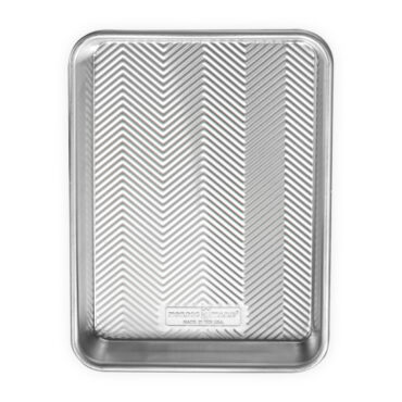 Nordic Ware Prism aluminum 9x13 rectangular baking pan with geometric chevron pattern, natural finish