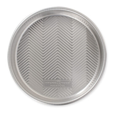 Nordic Ware aluminum 9-inch round cake pan with geometric chevron pattern on bottom, silver finish