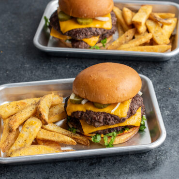 Nordic Ware aluminum eighth sheet pans holding cheeseburgers with golden fries, natural silver finish