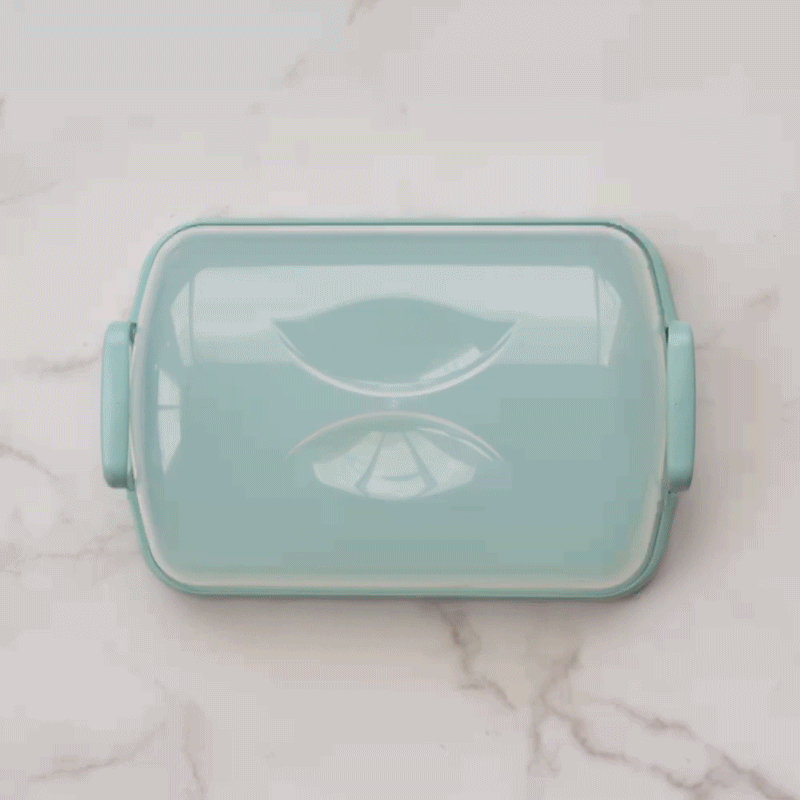 Nordic Ware clear plastic cake carrier with domed lid and white base, showing assembly process
