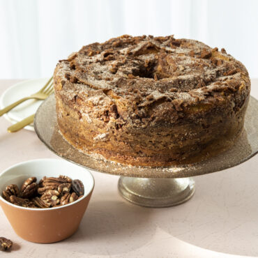 Golden tube cake with hollow center baked in Nordic Ware aluminum tube cake pan, showing tall ring shape