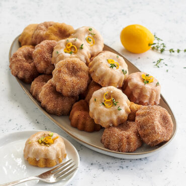 Mini bundt cupcakes with lemon glaze and cinnamon sugar arranged on white platter, golden brown baked