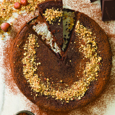 Chocolate hazelnut torte with nuts on top baked in Nordic Ware 9-inch springform pan, golden brown crust
