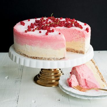 Nordic Ware 9-inch springform pan with sliced pink strawberry cheesecake, showing removable side mechanism