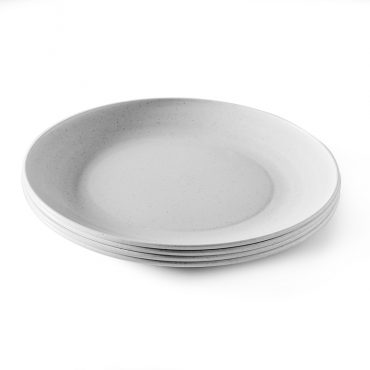 Four white plastic microwave-safe picnic plates stacked together, round with shallow rims
