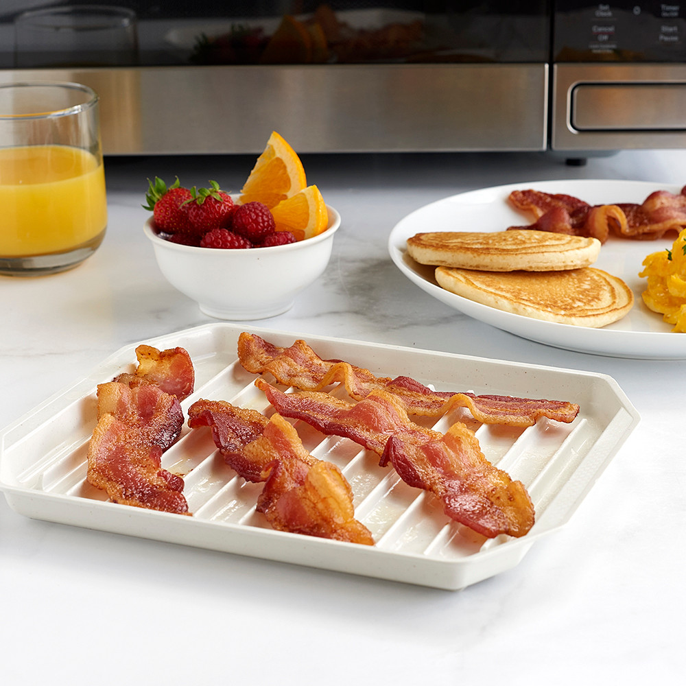 Image of bacon cooked on microwave bacon cooker with microwave in the background