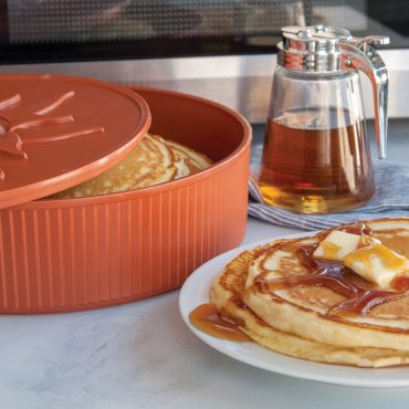 Nordic Ware terracotta tortilla pancake warmer with golden pancakes inside, served pancakes with butter and syrup