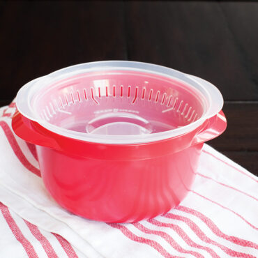 Nordic Ware white plastic multi-boiler with clear vented lid placed upside down inside container
