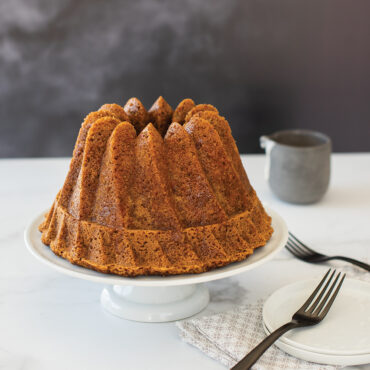 Golden-brown bundt cake baked in Nordic Ware Kugelhopf pan, displaying distinctive swirled turban design