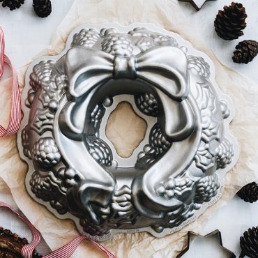 Nordic Ware cast aluminum Holiday Wreath Bundt pan with holly, pinecone, and bow details, silver finish