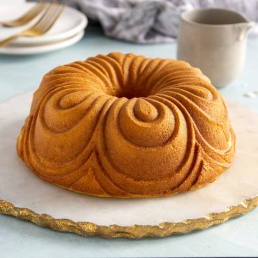 Golden chiffon bundt cake from Nordic Ware pan, showing elegant swirled pattern design on white plate