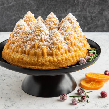 Golden bundt cake with detailed pine tree texture from Nordic Ware Pine Forest pan, dusted with powdered sugar