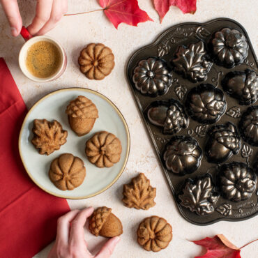 Plated Autumn Cakelets with mug of coffee and Pan with leaves, hands grabbing coffee and a cakelet