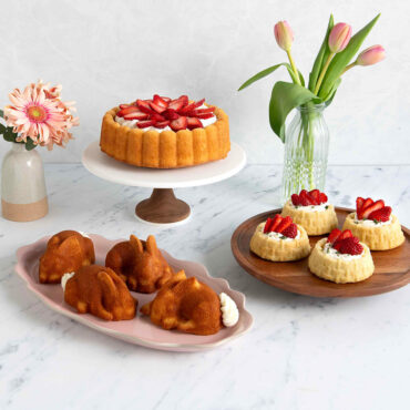 Three desserts made with Nordic Ware pans: basket-shaped shortcakes with strawberries, charlotte cake with berries, and small bunny-shaped cakes
