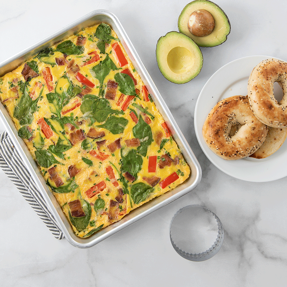 Nordic Ware aluminum quarter sheet pan with baked egg casserole, golden brown with herbs and vegetables