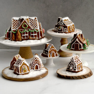 Two golden gingerbread house cakes baked from Nordic Ware Gingerbread House Duet Pan, decorated with white icing