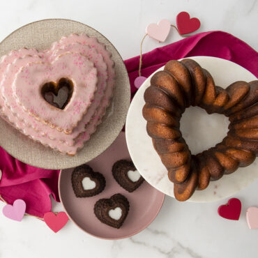 Pink frosted heart cake and golden bundt heart cake from Nordic Ware tiered heart cakelet pan with chocolates