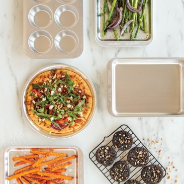 Nordic Ware aluminum crisping sheet with golden roasted vegetables and baked chicken pieces