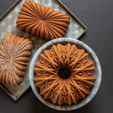 Golden bundt cakes baked in Nordic Ware Cut Crystal and other decorative bundt pans, showing intricate geometric patterns